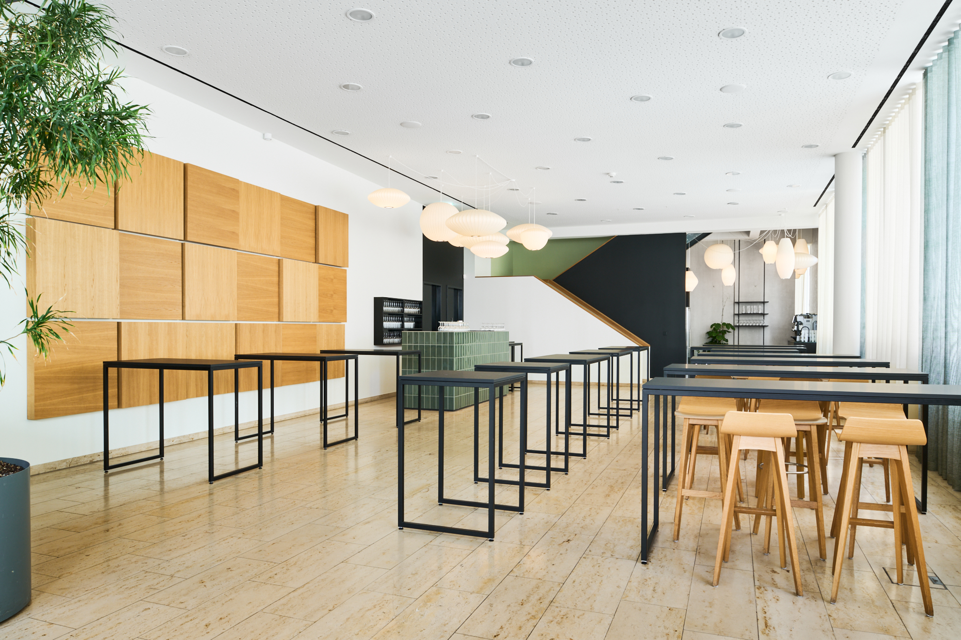 Moderne Innenansicht eines Studienzentrums mit Holz- und Metallmöbeln, Pflanzen und hellem, einladendem Licht.